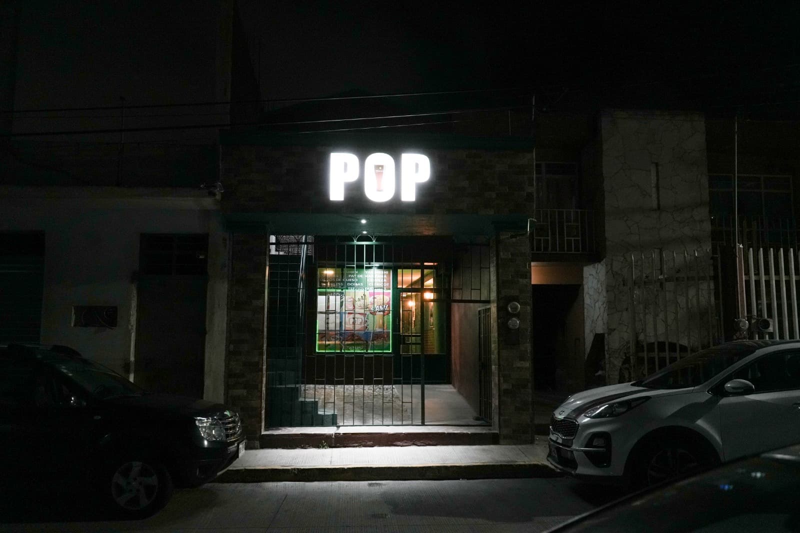 Entrada del restaurante POP Perote, fachada iluminada con letras doradas
