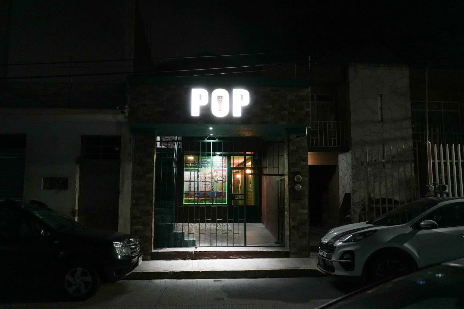 Entrada del restaurante POP Perote, fachada iluminada con letras doradas